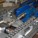Heavy-duty conveyor system components, including roller and drag chain mechanisms, designed for automated pallet movement in sterilization and aeration processes.