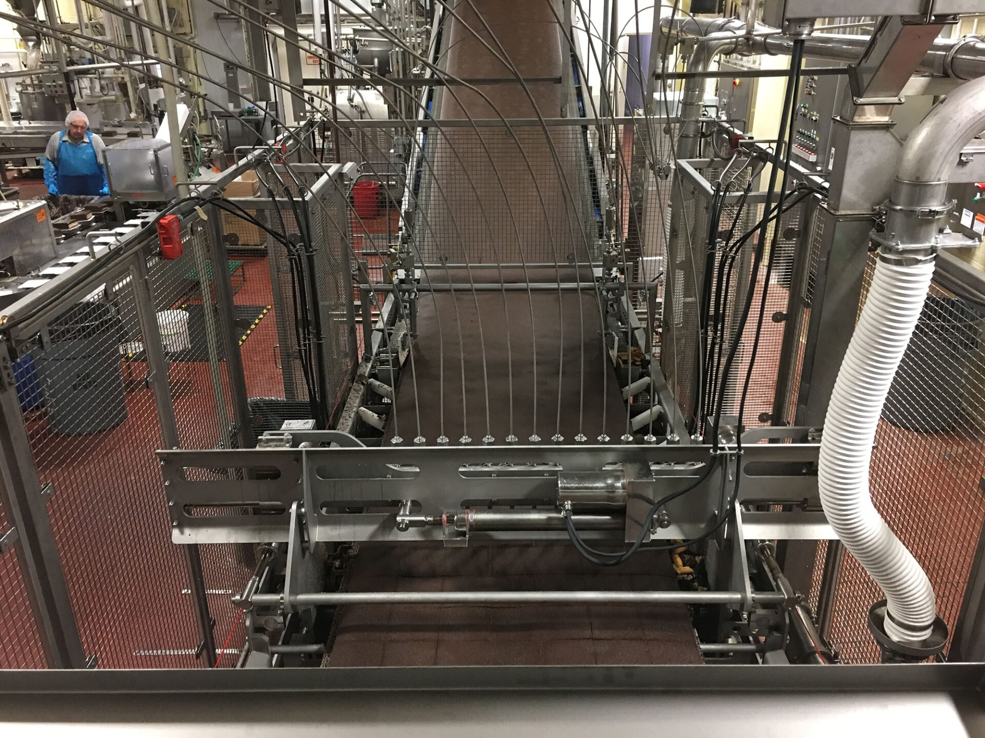 Custom cake handling system featuring metal conveyor structure, integrated equipment, and processing line setup in food production environment.