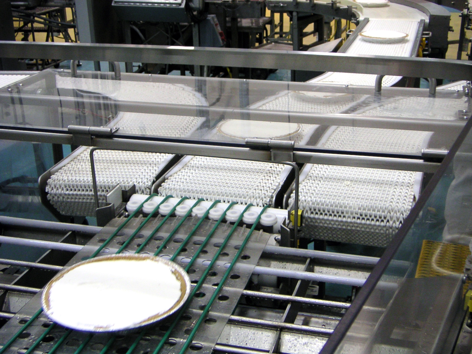 Custom dessert handling system featuring conveyor belts transporting plates, designed for efficient food processing and automation by CHL Systems Inc.