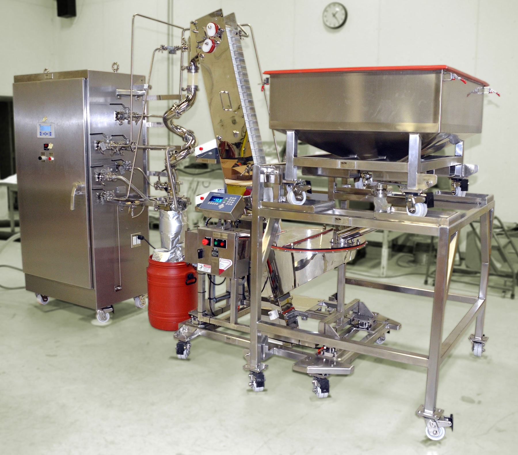 Tablet packaging system featuring stainless steel construction, integrated conveyor, control panel, and storage hopper, designed for food processing automation by CHL Systems Inc.