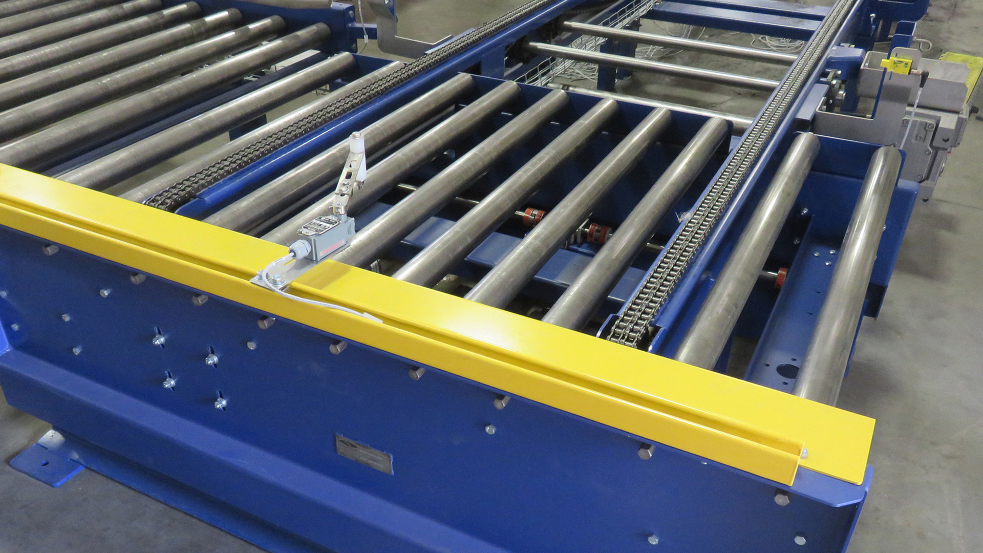 Heavy duty pallet conveyor system with robust rollers and yellow safety edge, designed for efficient material handling in food industry applications.