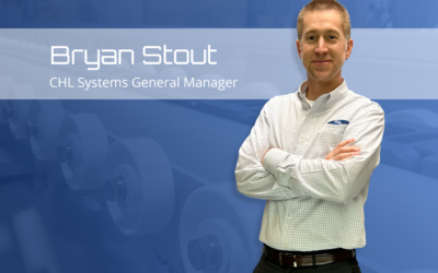 Bryan Stout, General Manager of CHL Systems, standing confidently with arms crossed against a blue background, featuring automation equipment.