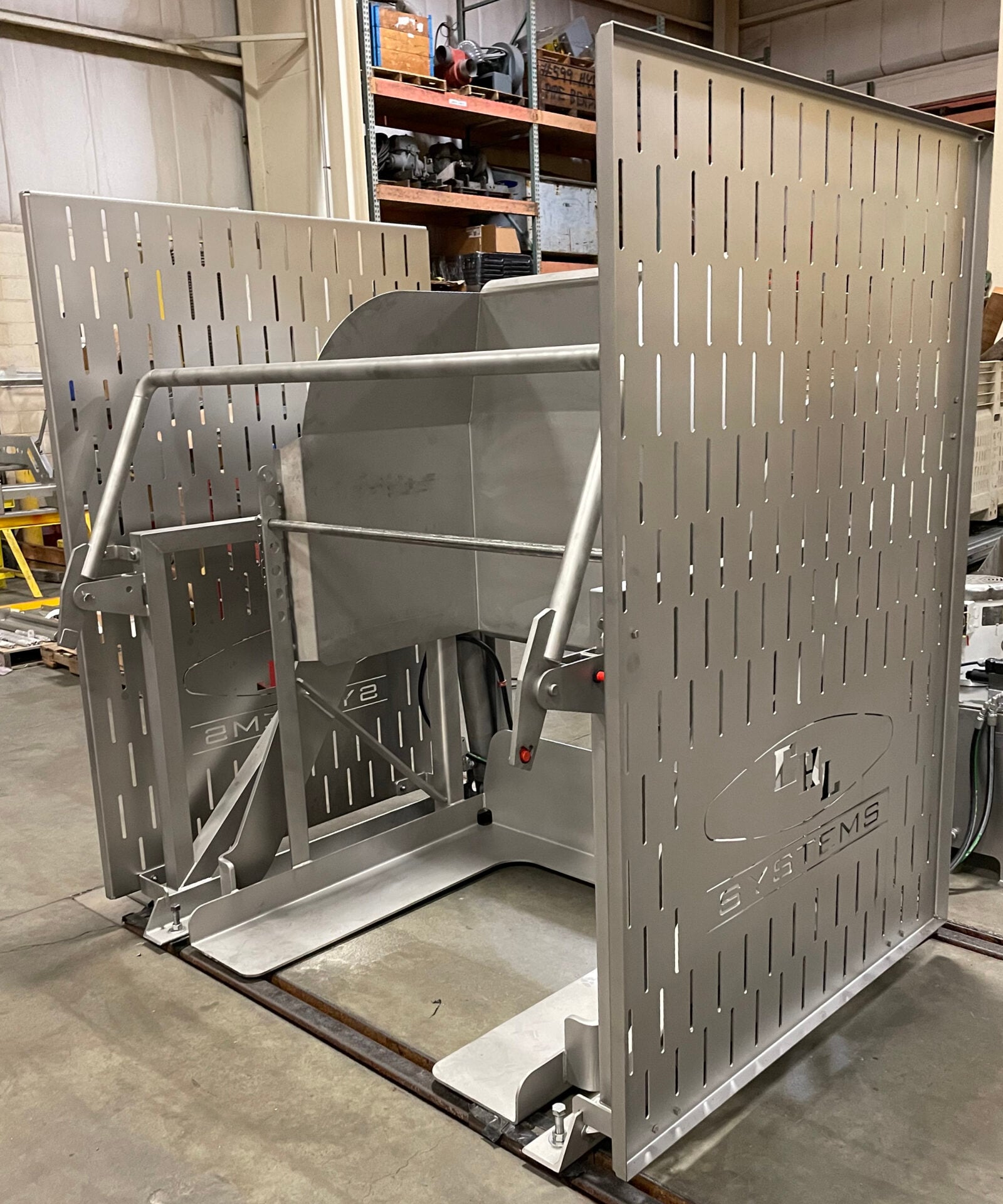 Batching dumper equipment by CHL Systems, showcasing stainless steel construction and perforated panels, designed for food processing automation in a facility setting.