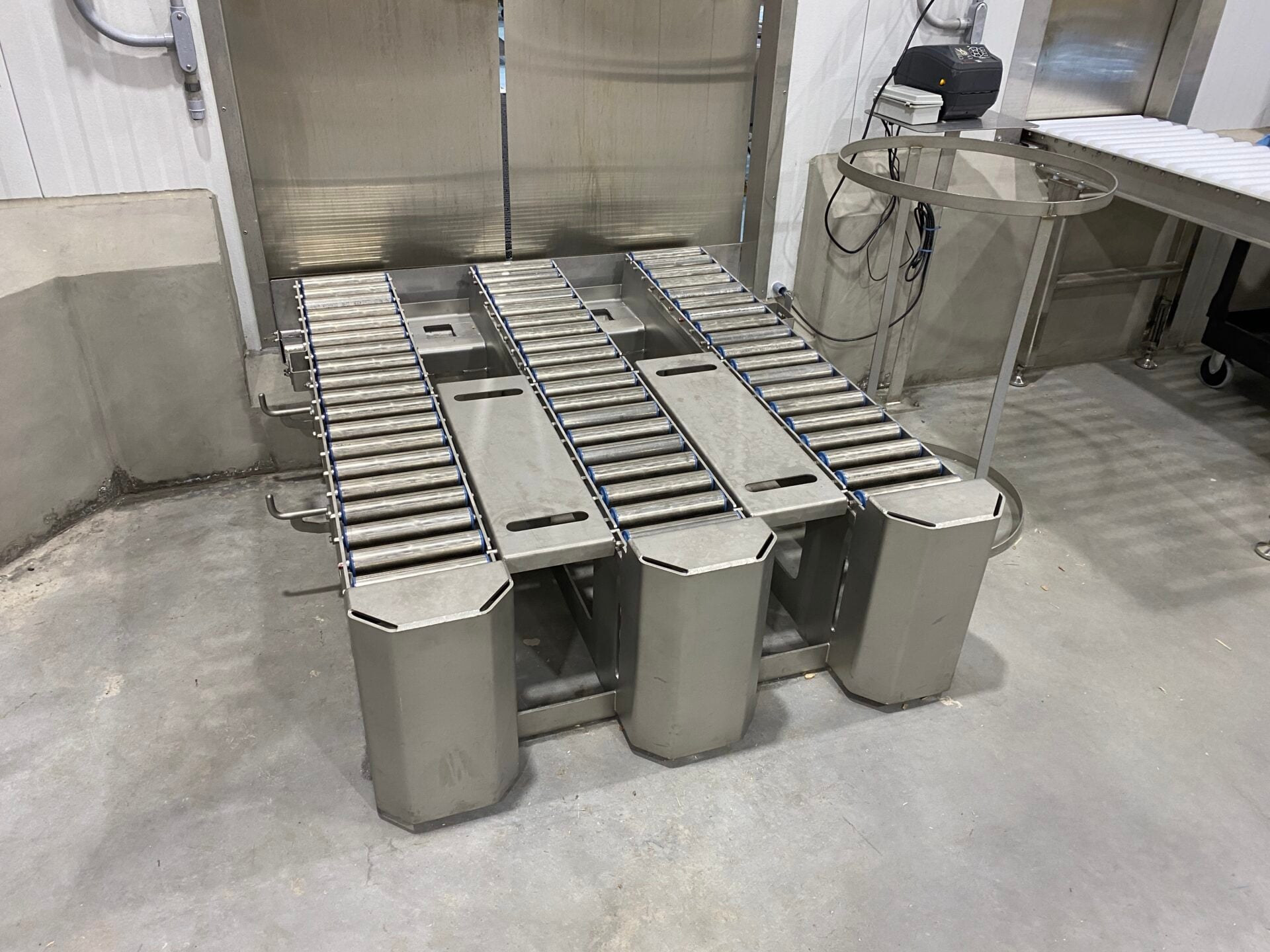 Bulk tote conveyor system designed for efficient material handling in food processing facility, featuring stainless steel construction and integrated roller tracks.