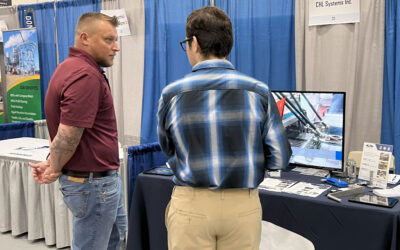 Two individuals engaging at CHL Systems booth during the Penn Tech Fall Career Fair, showcasing automation solutions for food production.