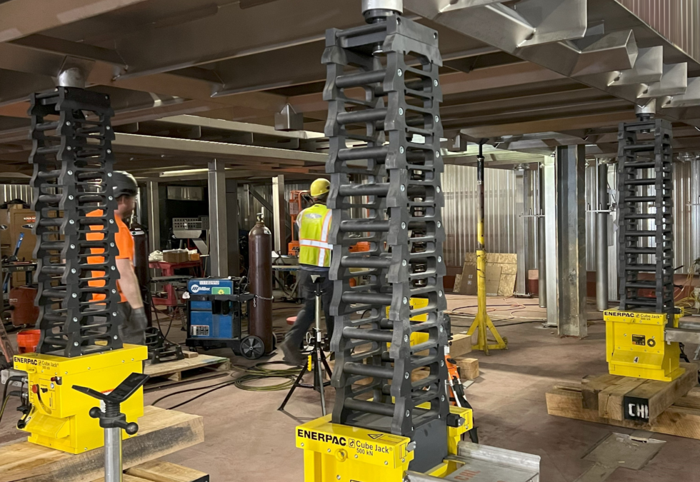 Enerpac cube jacks and structural supports in a food processing facility, showcasing engineering solutions for vertical weigh scale platform construction.
