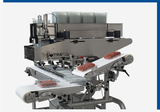 QUPAQ denesting machine with hygienic design, featuring trays of ground meat on conveyor belts, integrated into food production line for efficient tray dispensing.