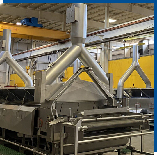 Industrial food processing equipment featuring stainless steel design, showcasing automated systems for production efficiency in a manufacturing facility.